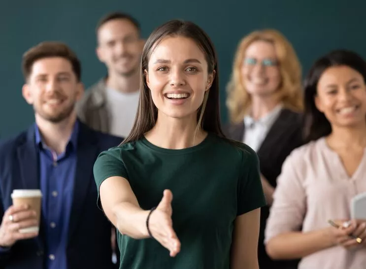 Woman company representative holds out hand for handshake welcoming client Meet_Avatar_Team_Avatar_Recovery_Center